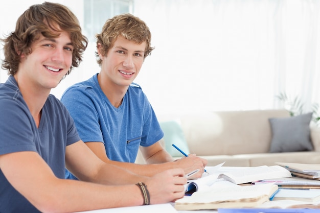 写真 カメラを見て、笑っている2人の学生の側面図