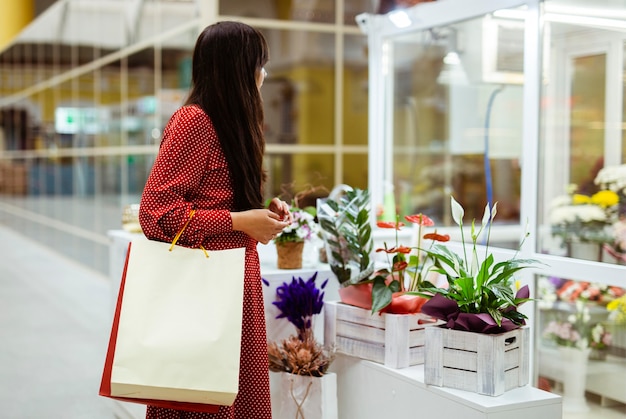 写真 ショッピングバッグを持って植物を買う女性の側面図