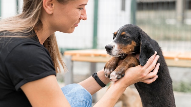写真 避難所でかわいい救助犬を保持している女性の側面図