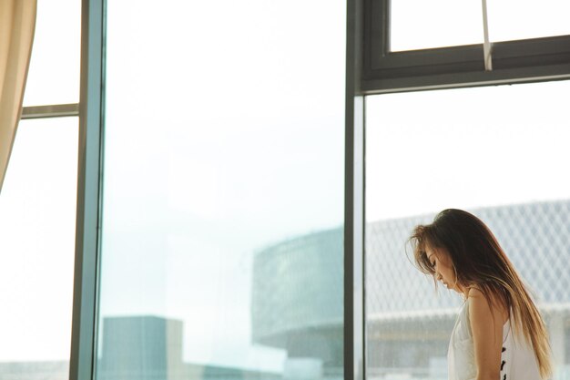 写真 窓から見る女性の横の景色