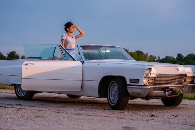 写真 空に向かって車の上に立っている女性のサイドビュー