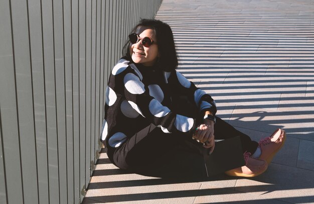 사진 산책로 에 앉아 있는 선글라스 를 착용 한 여자 의  면