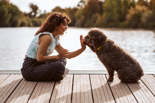 写真 硬木の床の上で犬を飼っている女性の横の景色