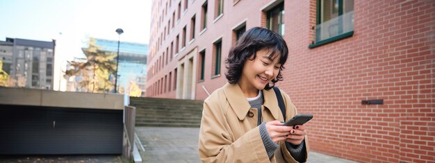 写真 都市で携帯電話を使っている若者の横の景色