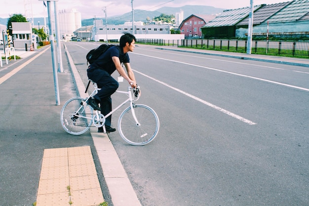 사진 도로 에 자전거 를 타고 있는 청년 의 측면 전망