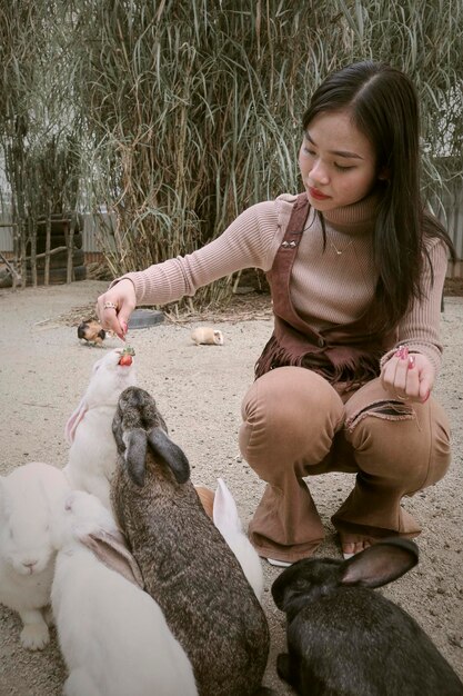 写真 フィールドに座っている若い女性のサイドビュー