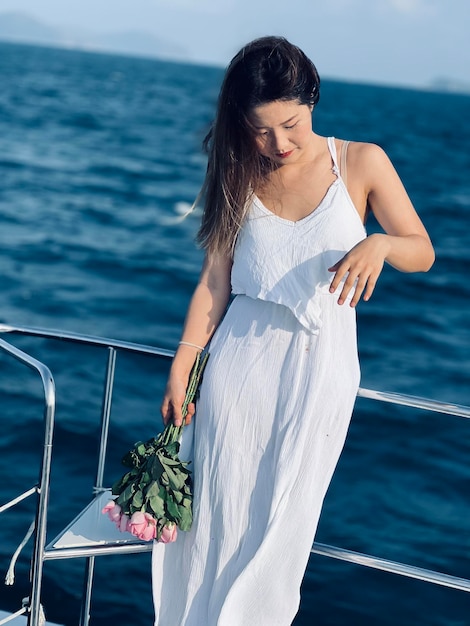 Фото Боковой вид молодой женщины, стоящей у моря