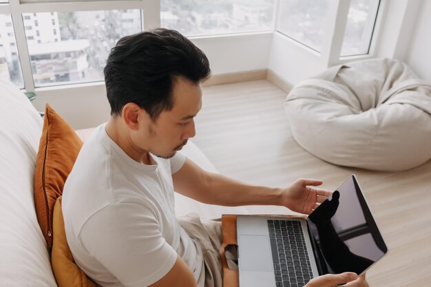 写真 家でラップトップを使用している若い女性のサイドビュー