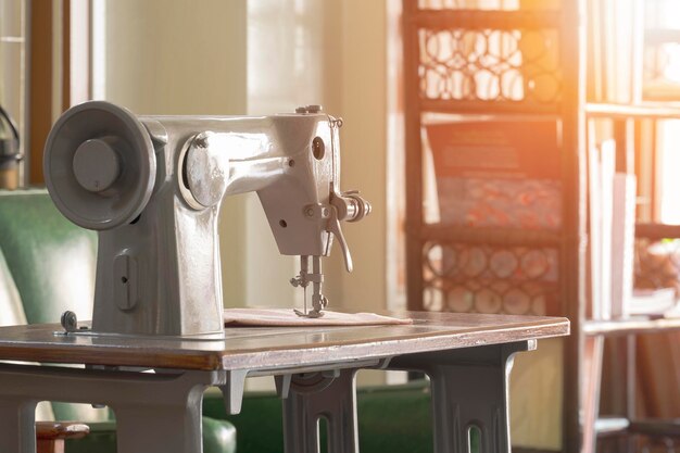 Side view of the old vintage gray sewing machine in living room at home