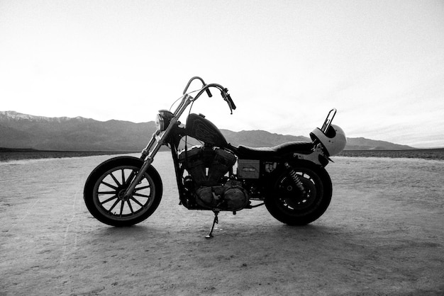 Photo side view of parked motorcycle against clear sky