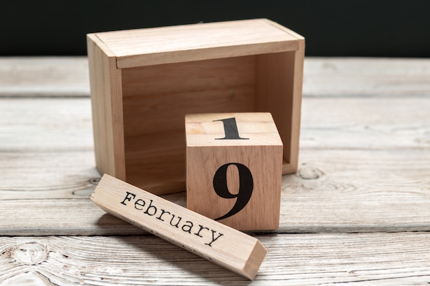 Side view of parts of wooden calendar on dark wooden table 