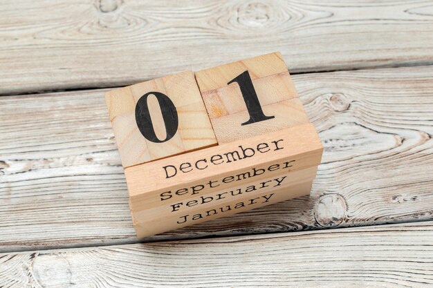 Side view of parts of wooden calendar on dark wooden tabletop