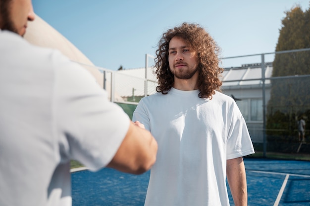 Persone di vista laterale che stringono la mano