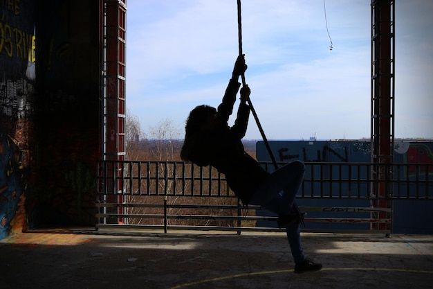 Photo side view of person swinging on rope at teufelsberg