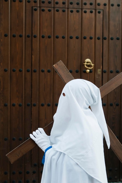 Photo side view of person wearing costume standing by wooden wall