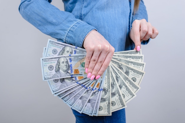 Side view photo of woman holding pile of money