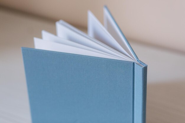 Side view of photobook on white wooden table