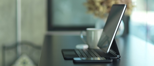 Side view of portable workspace with tablet, smartphone and decorations in cafe