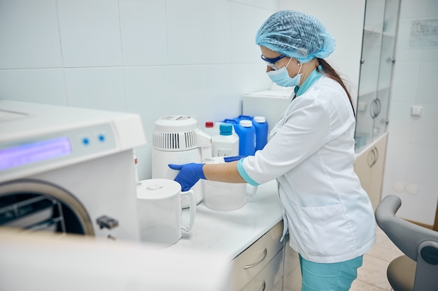 Side view portrait of beautiful nurse cleaning in the workplace and disinfection all dentist room