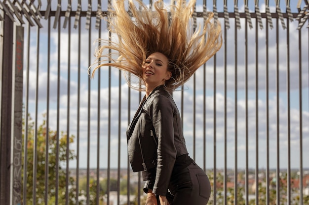 Photo side view portrait of beautiful woman with blond hair standing against fence