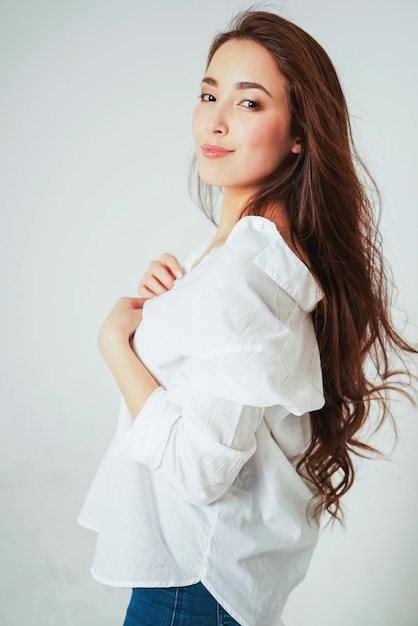 side view portrait of beautiful young woman standing against white background