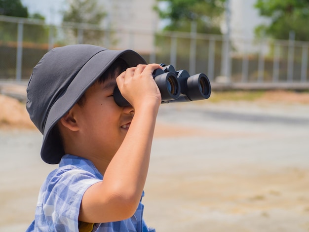Side view portrait of boy holding camera