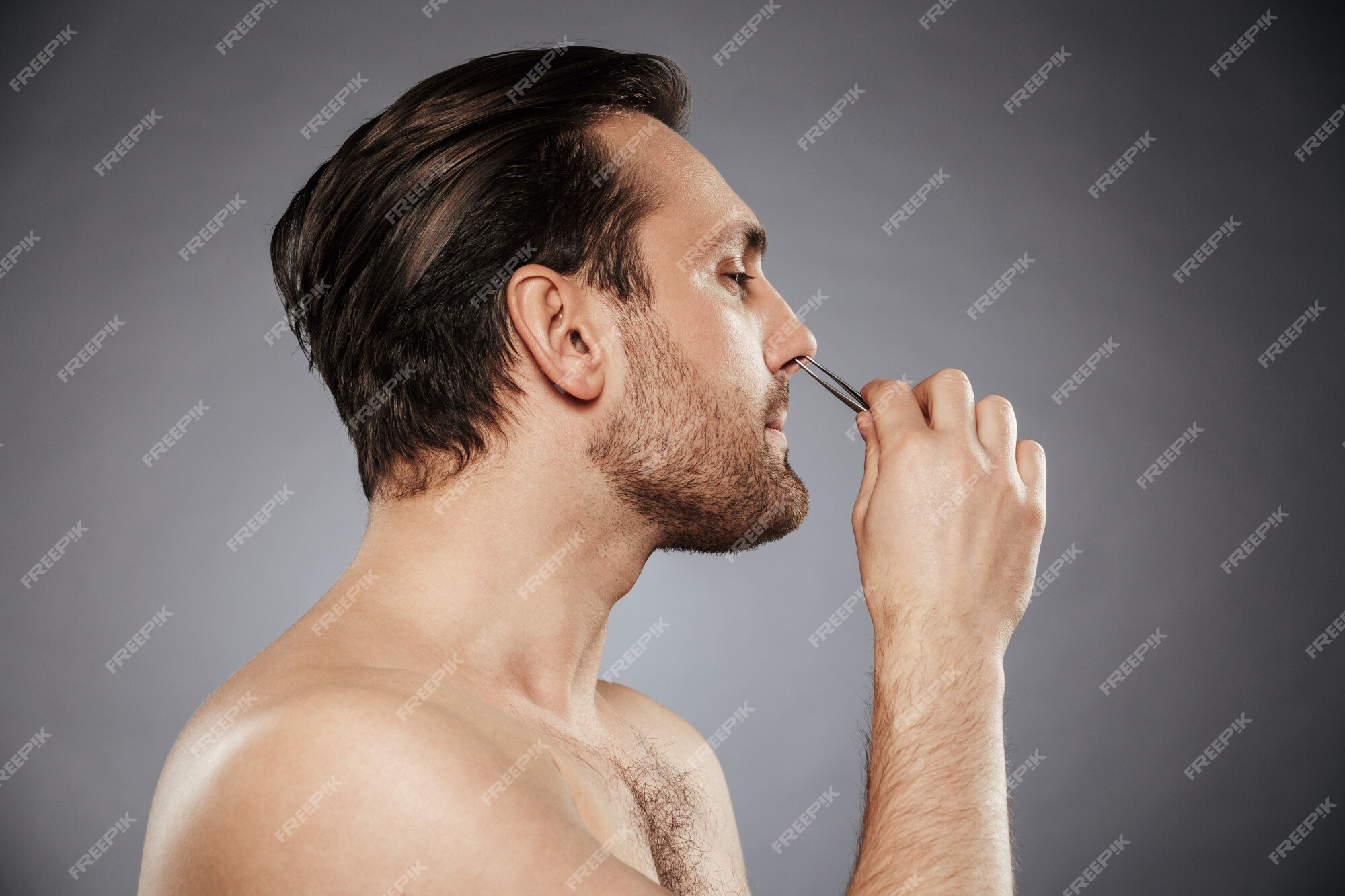 Premium Photo | Side view portrait of a handsome man removing nose hair