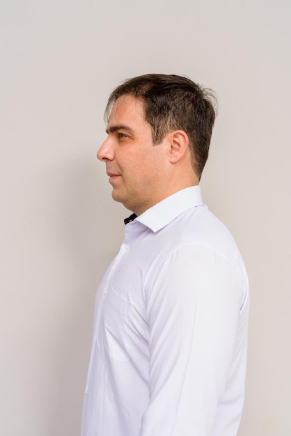 Side view portrait of handsome Persian man against plain background