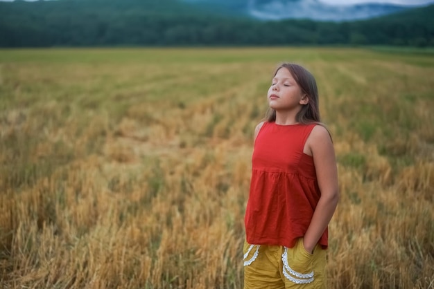 Side view portrait of happy beautiful girl breathing fresh air in field outdoors High quality photo