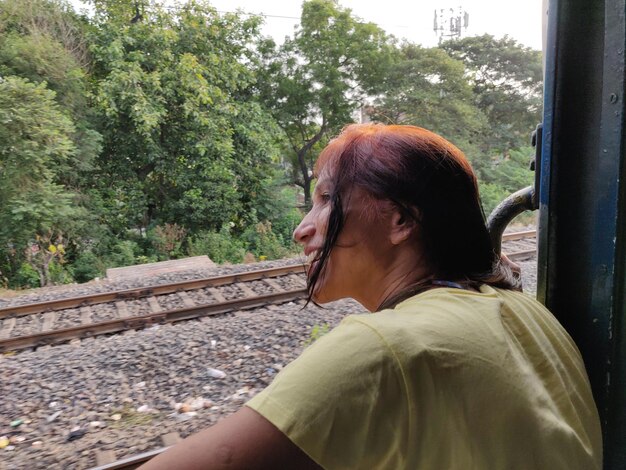 鉄道線路に座っている成熟した女性のサイドビューの肖像画