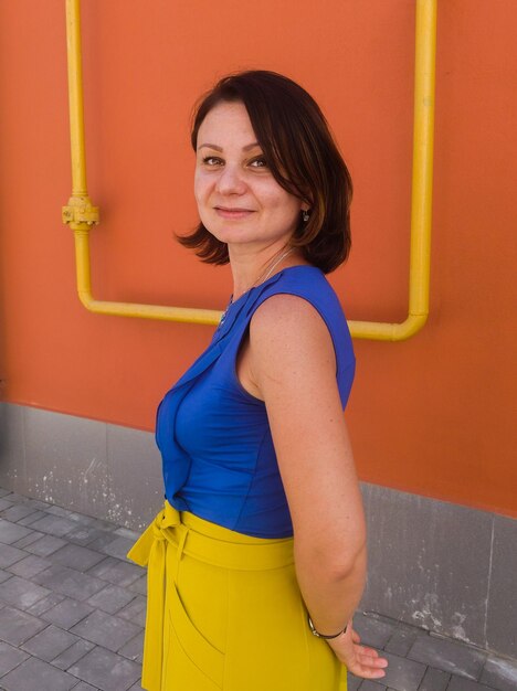 Side view portrait of woman standing against wall