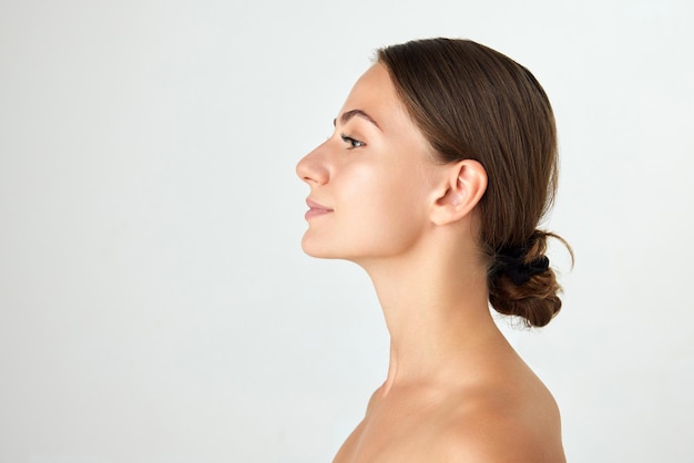 Side view portrait of young beautiful woman with perfect face shape isolated on white background