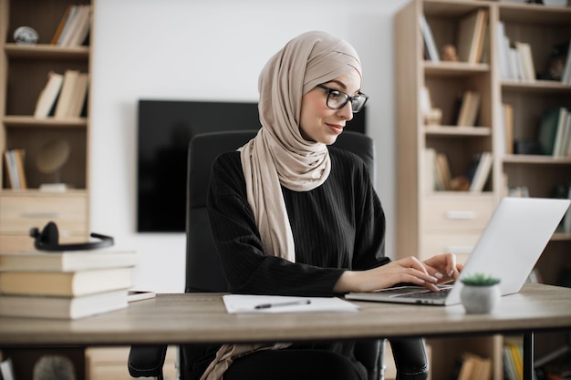 Side view portrait of young experienced smart stylish muslim manager in eyeglass businesswoman