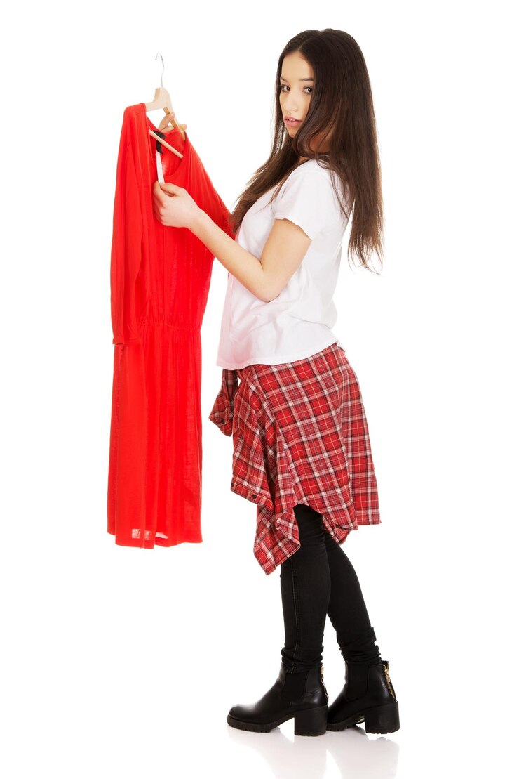 फोटो side view portrait of young woman checking price tag on red dress against white background