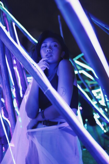 Side view portrait of young woman standing against lights