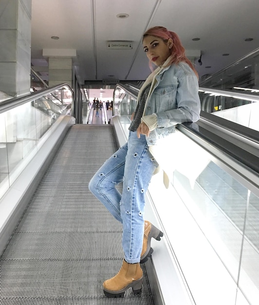 side view portrait of young woman standing on escalator