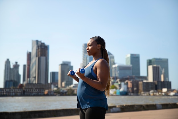 Photo side view pregnant woman doing sport outdoors