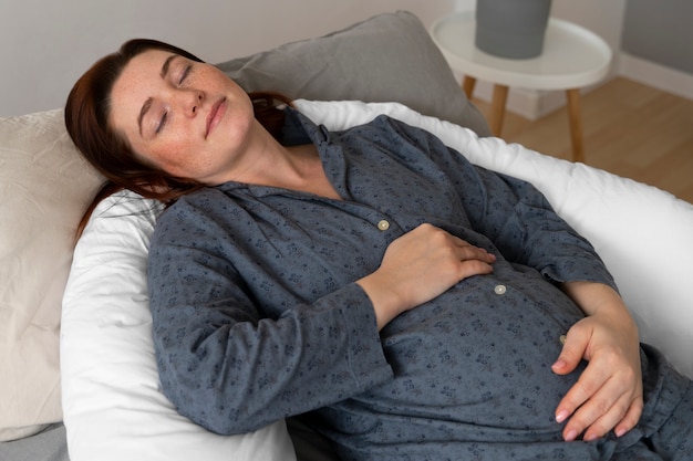 Photo side view pregnant woman laying at home