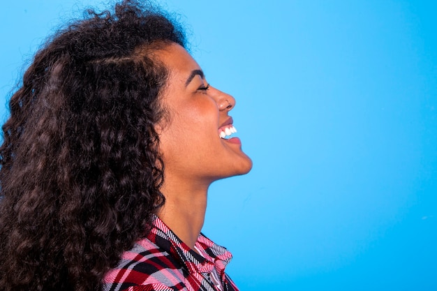 side view of pretty african woman beauty on blue background - Imagem.