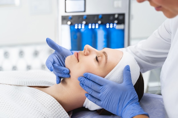 Side view of a pretty woman lying with her eyes closed during a skin checkup