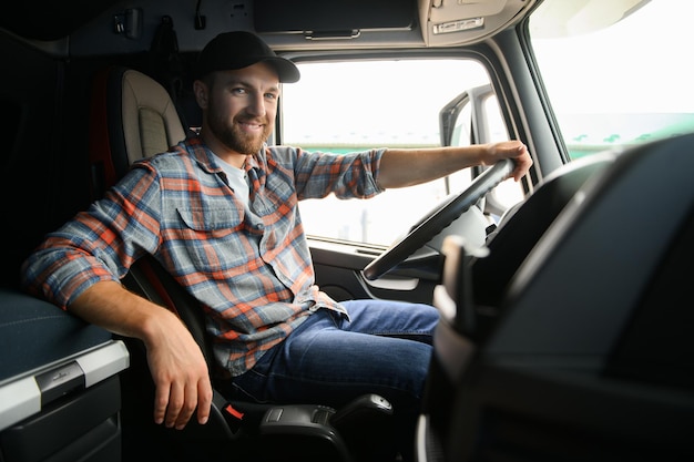 Side view of professional driver behind the wheel in truck's cabin