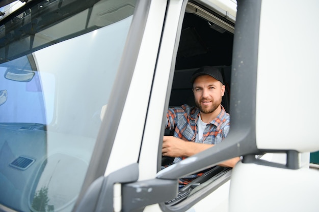 Side view of professional driver behind the wheel in truck's cabin