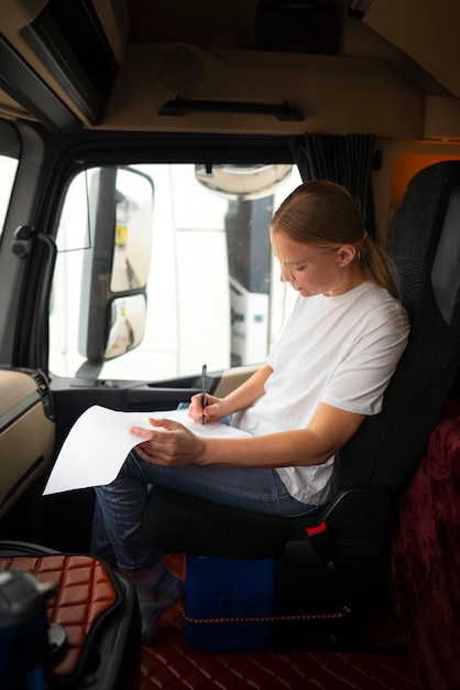 Foto autista femminile professionale di vista laterale in camion