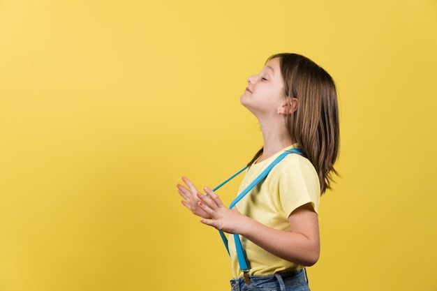 Side view of proud little girl wearing suspenders