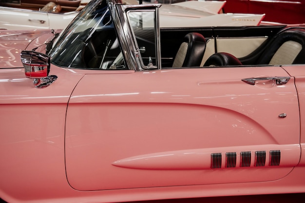 Вид сбоку на редкий розовый кабриолет