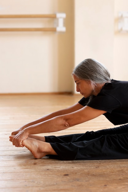 Photo side view senior woman dancing in studio