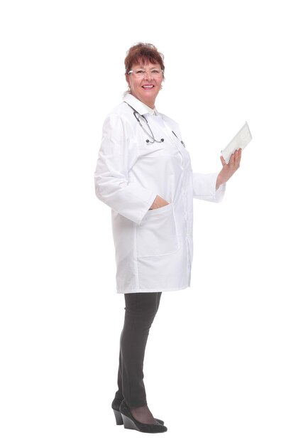 Side view of senior woman doctor with stethoscope write on tablet looking at camera