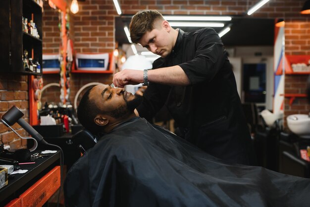 Side view of serious man with stylish modern haircut looking forward in barber shop