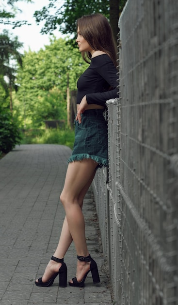 Side view shot of casual woman in jeans shorts outdoor