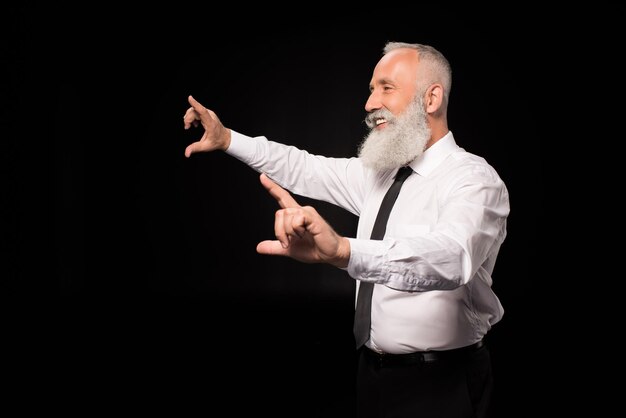 Side view shot of man in a suit laughing and pointing his fingers pretending to use touch screen